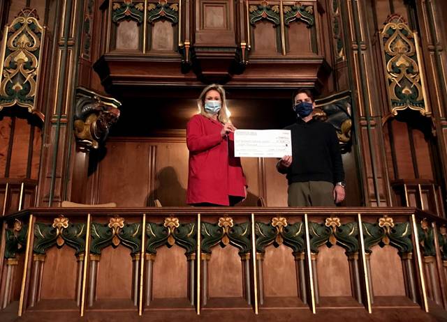 Betsy McGrath Ardizoni, SCC Development Director and Jason Helman, SCC Business Manager, pose with a facsimile of a check in the Harry & Jeanette Weinberg Theatre.
                                 Submitted photo