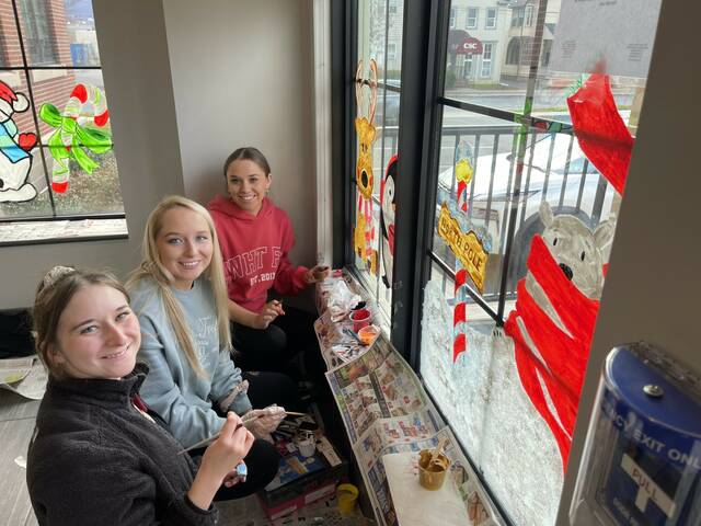 35 volunteers participate in silver anniversary of holiday window painting