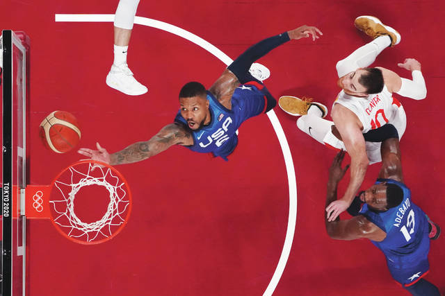 Team USAs Damian Lillard (6) drives to the basket past Spains Victor Claver (10) during Tuesdays Olympic quarterfinals in Saitama, Japan.
                                 Brian Snyder | AP photo, pool